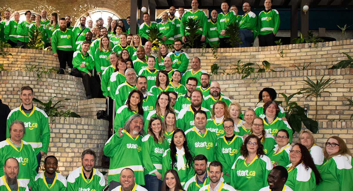 large group of Start.ca employees in their hockey jerseys