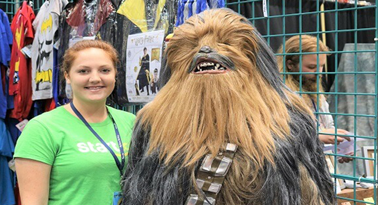 an employee posing with Chewbacca