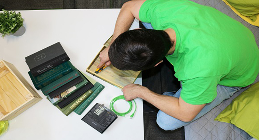 man sitting over desk building a wooden container