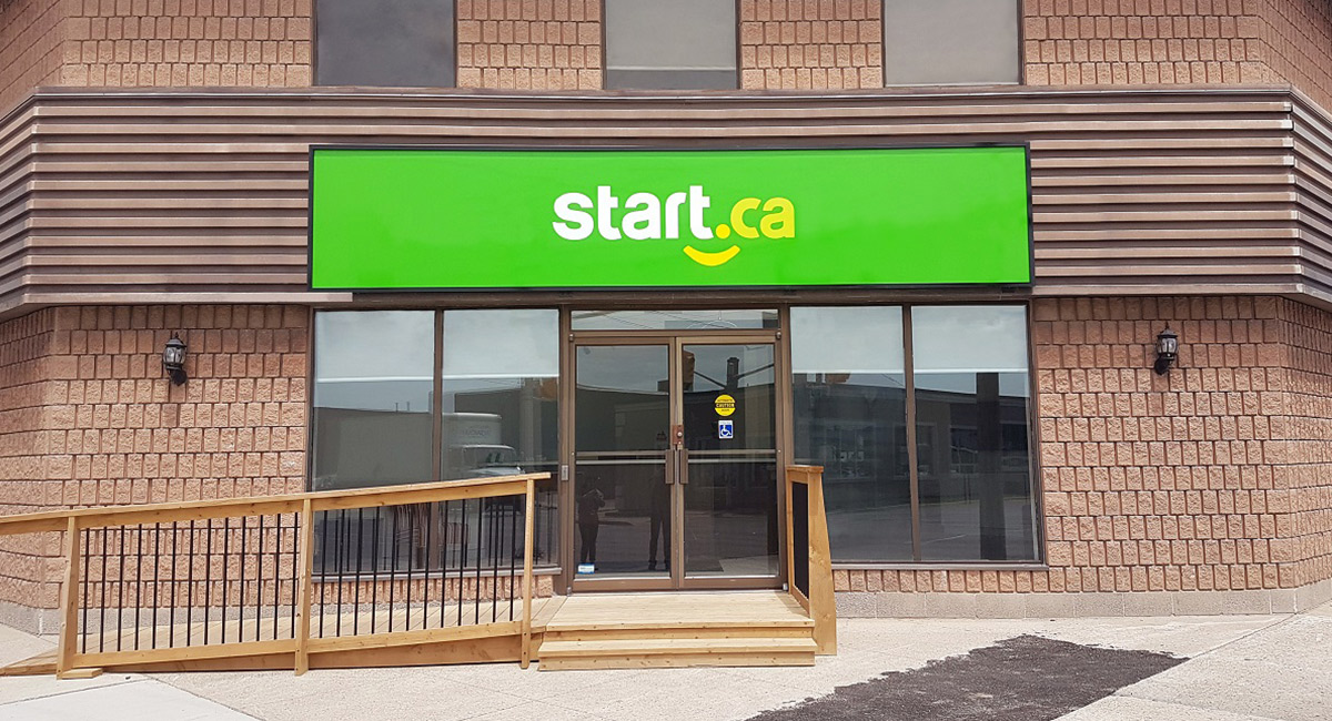 front of business with green sign and brick background