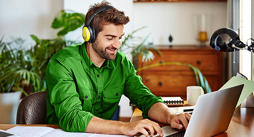 man in headphones behind a laptop