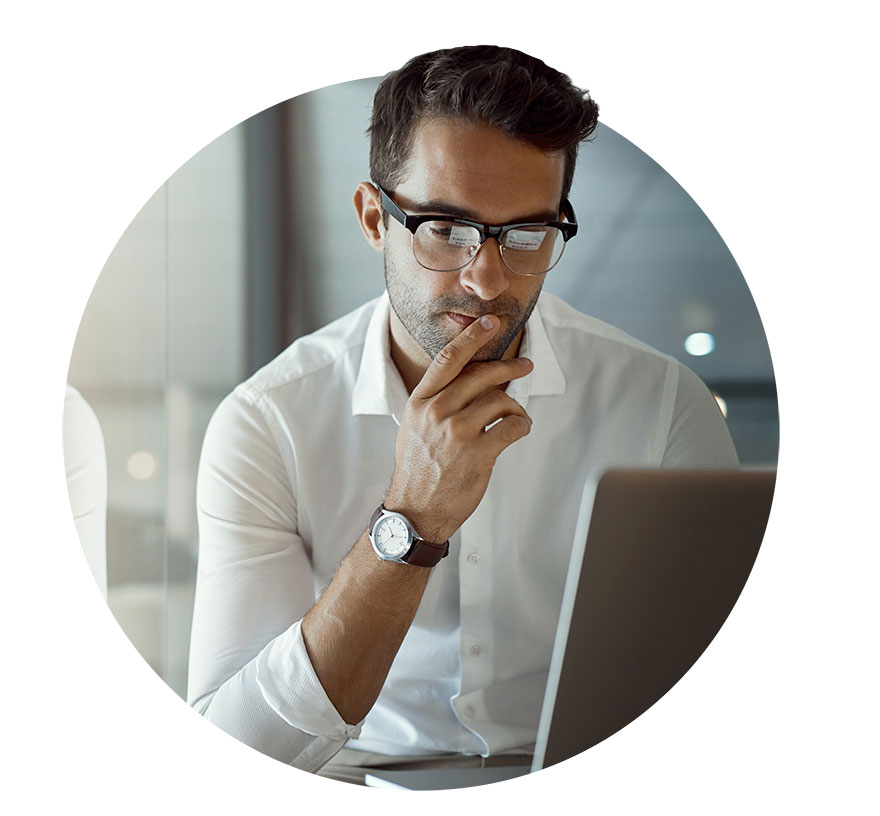 Office worker looking pensively at laptop with hand on his face wearing a white shirt and nice watch