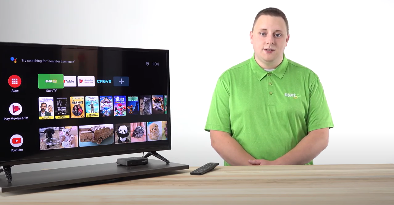 An employee in a green polo explaining how to uninstall and update apps next to a smart tv showing Youtube, Google Play, and Start.TV app