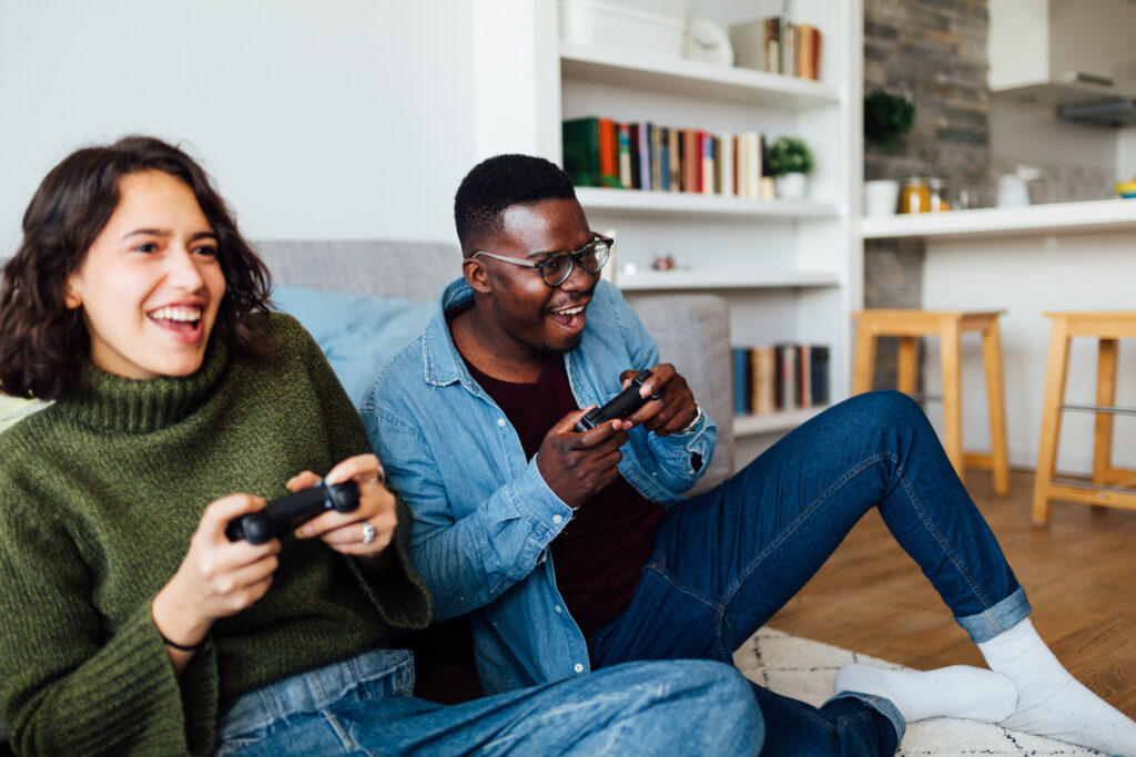 Happy smiling couple having fun at home, relaxing and playing video games, enjoying themselves